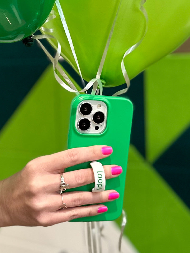 A woman holding a Loopy Green Loopy Case.|| feature-media