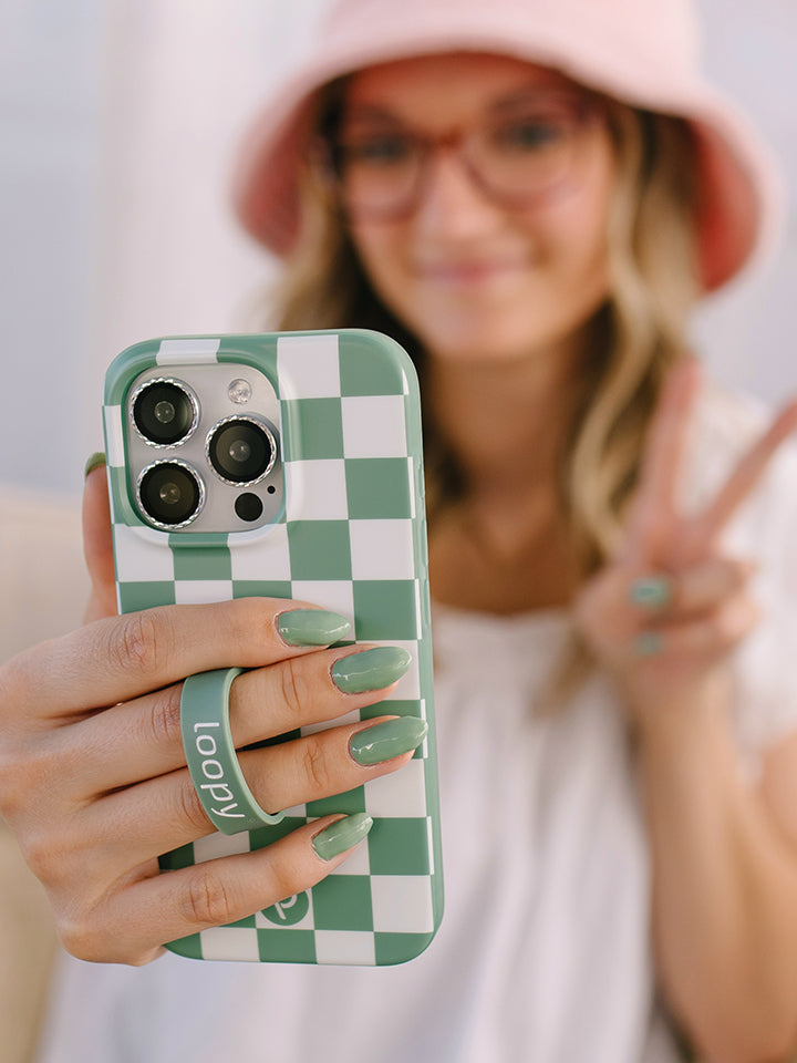 A woman holding a Green Checkered Loopy Case. || feature-media