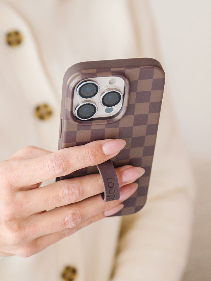 A woman holding a Cocoa Checkered Loopy Case. || feature-media