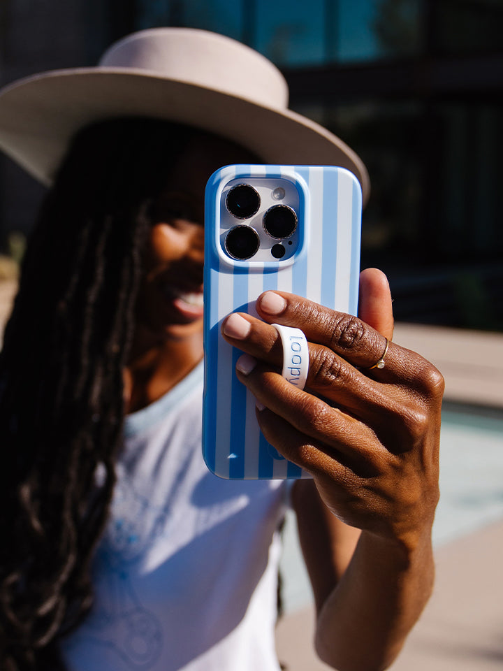 A woman holding a Blue Stripes Loopy Case. || feature-media