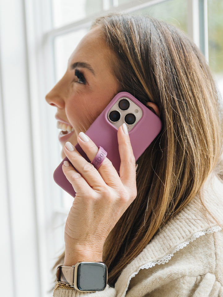 A woman talking on the phone while using a Dusty Plum Loopy Case. || feature-media