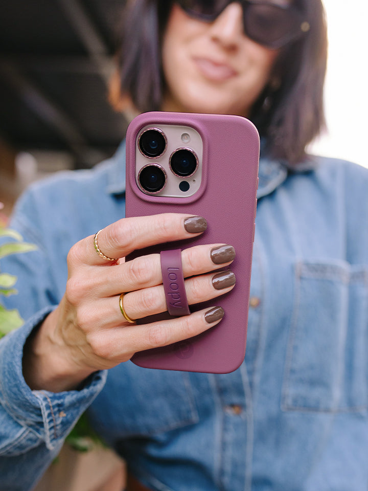 A woman holding a Dusty Plum Loopy Case. || feature-media