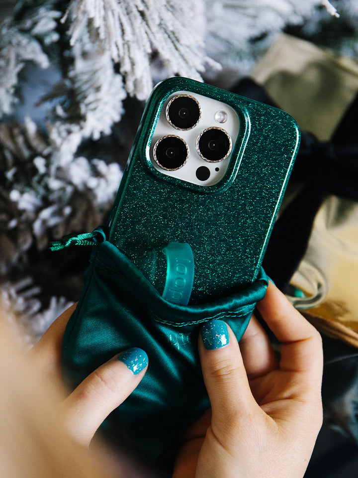 A woman holding an Emerald Sparkle Loopy Case.|| feature-media