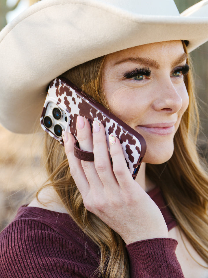 A woman holding a Pony Up Loopy Case. || feature-media