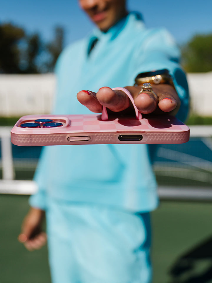 A woman holding a Blush Checkered Loopy Case. || feature-media