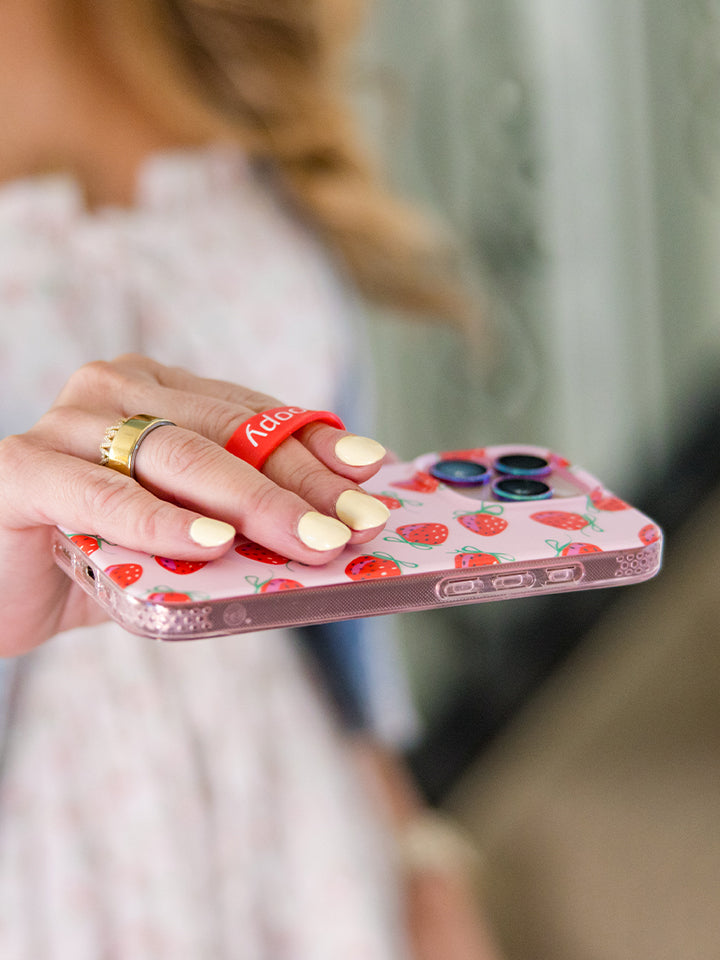 A woman holding a Berries and Bows Loopy Case. || feature-media