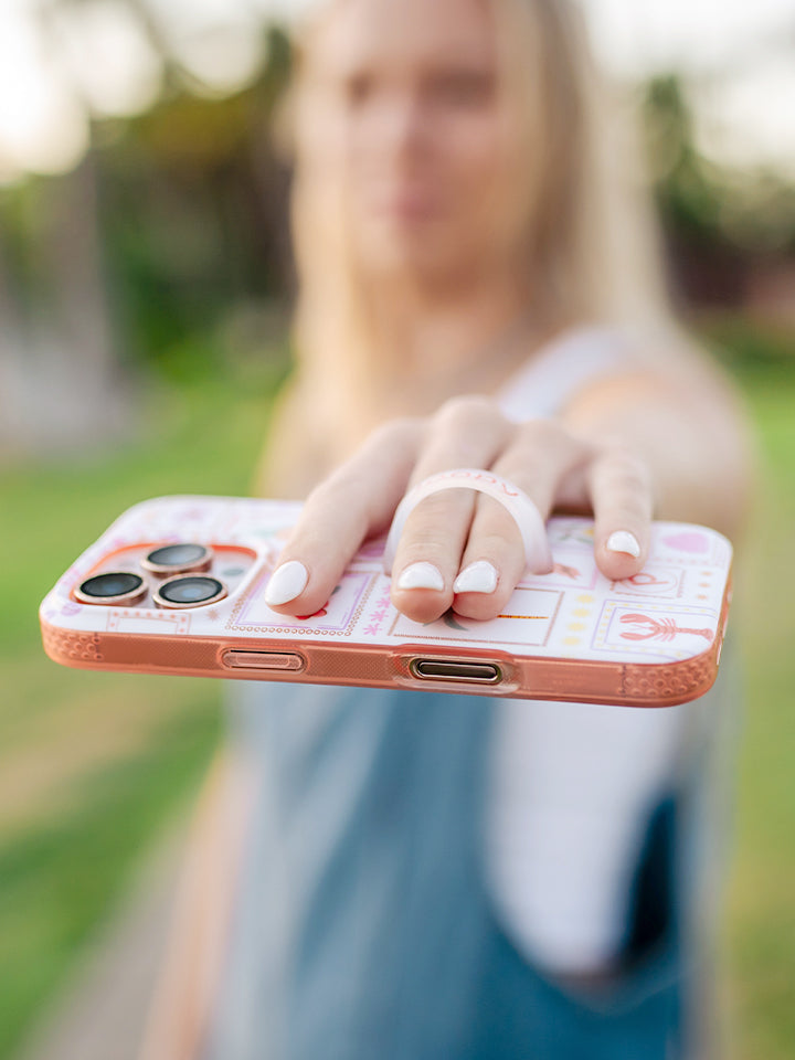 A woman holding a Seaside Stamps Loopy Case. || feature-media