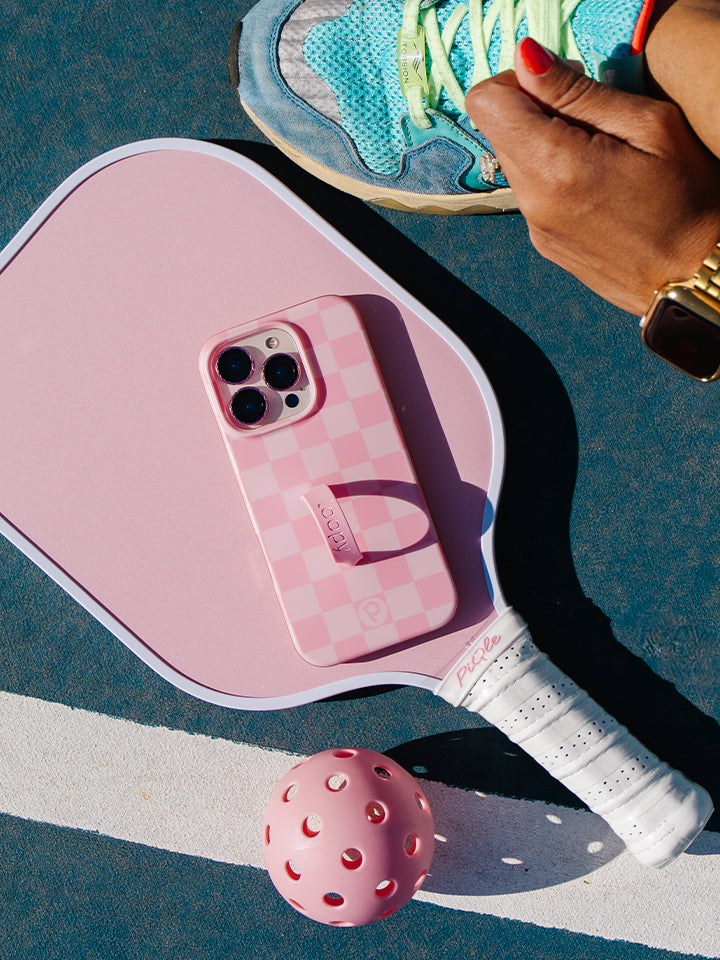 A woman holding a Blush Checkered Loopy Case. || feature-media