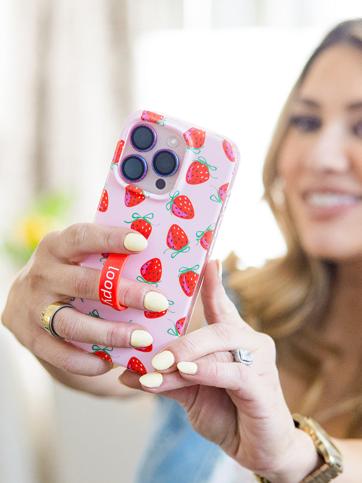 A woman holding a Berries and Bows Loopy Case. || feature-media