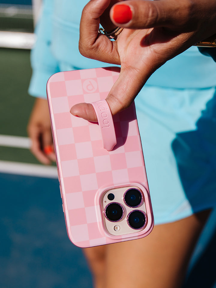 A woman holding a Blush Checkered Loopy Case. || feature-media