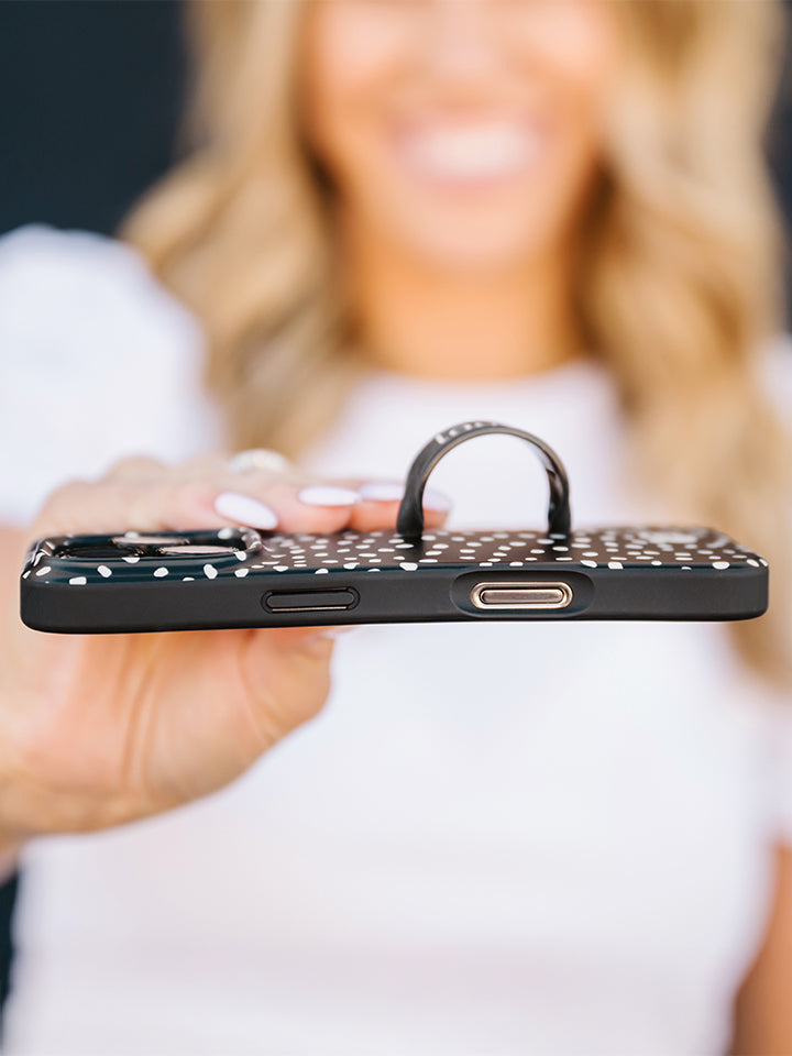 A woman holding a Noir Dots Loopy Case. || feature-media