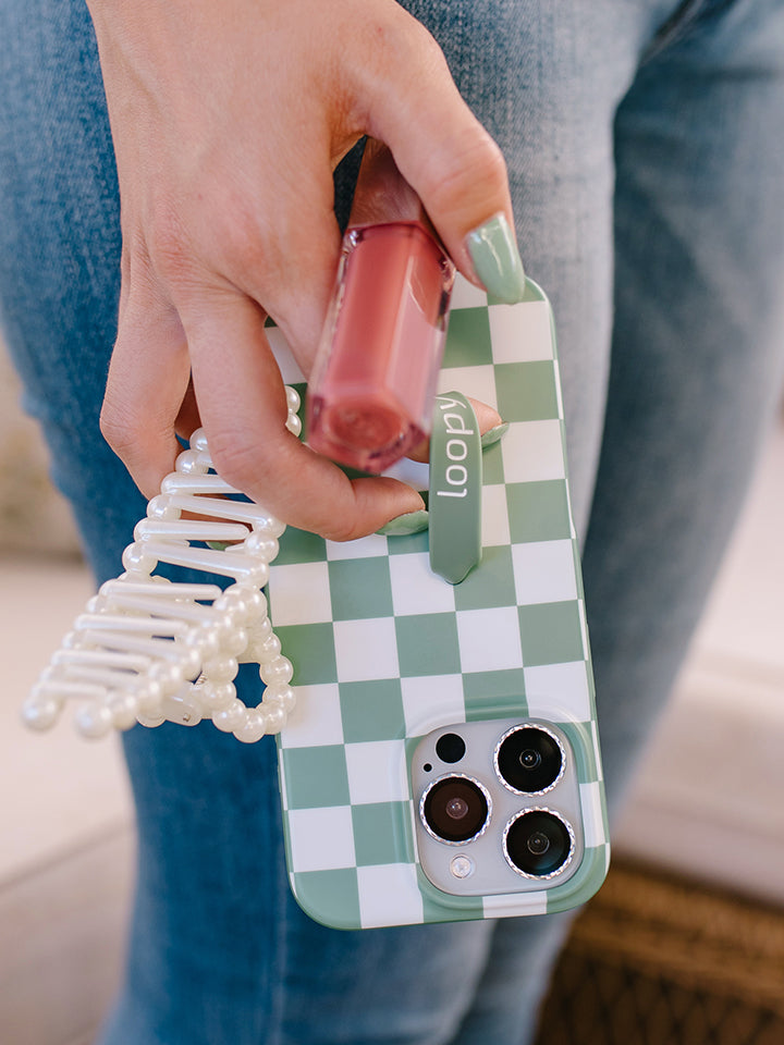 A woman holding a Green Checkered Loopy Case. || feature-media