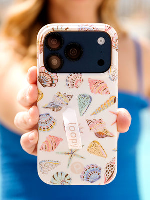 A woman holding a Coastal Shells Loopy Case. || feature-media