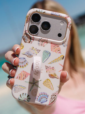 A woman holding a Coastal Shells Loopy Case. || feature-media