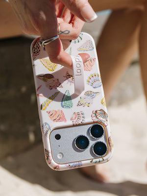 A woman holding a Coastal Shells Loopy Case. || feature-media