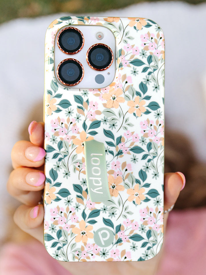 A woman holding an Apricot Blooms Loopy Case. || feature-media