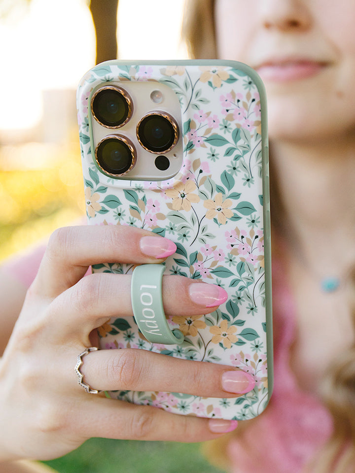 A woman holding an Apricot Blooms Loopy Case. || feature-media