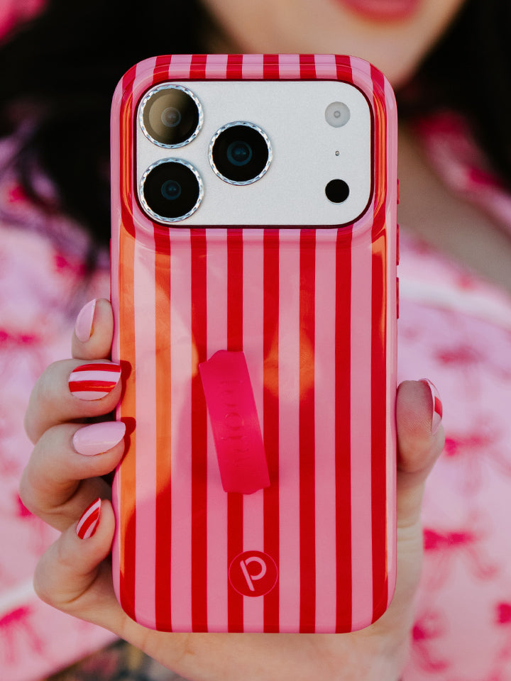 A woman holding a Berry Stripes Loopy Case. || feature-media