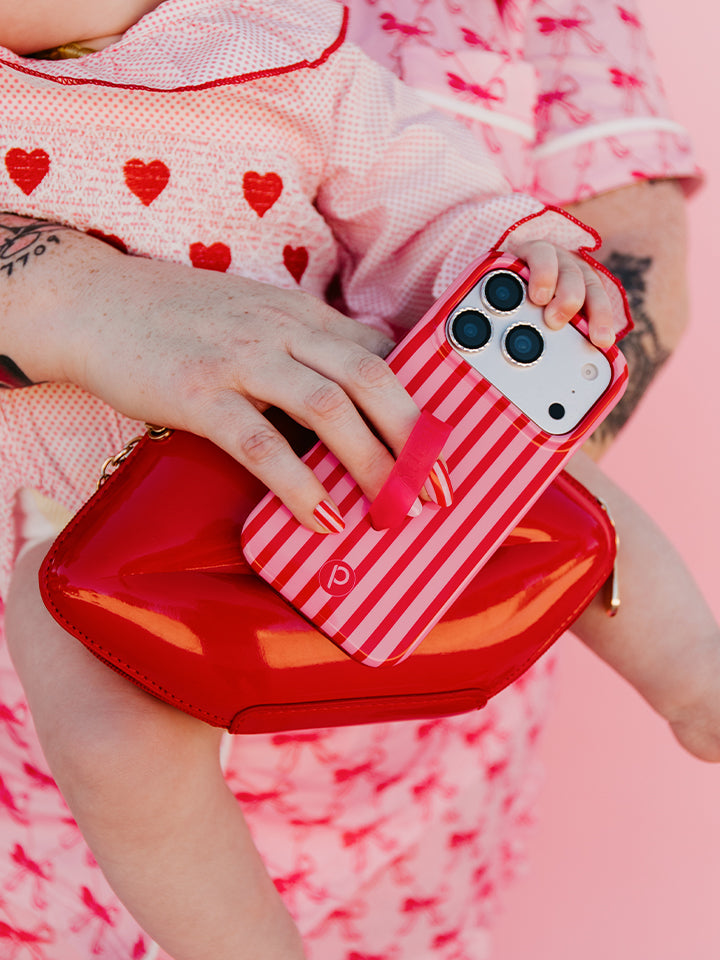 A woman holding a Berry Stripes Loopy Case. || feature-media