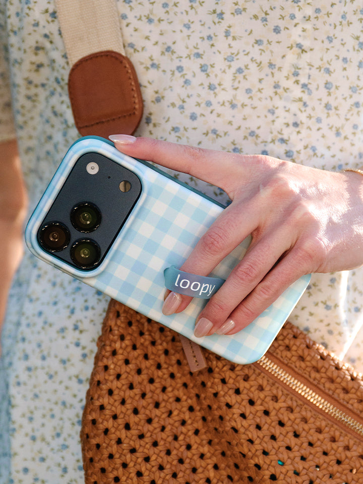 A woman holding a Blue Gingham Loopy Case. || feature-media