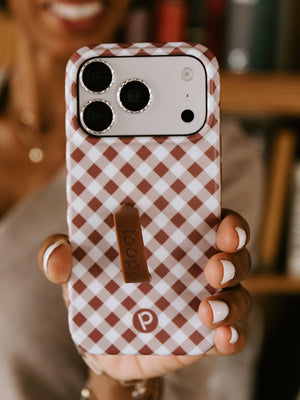 A woman holding a Brown Gingham Loopy Case. || feature-media