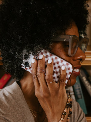 A woman holding a Brown Gingham Loopy Case. || feature-media