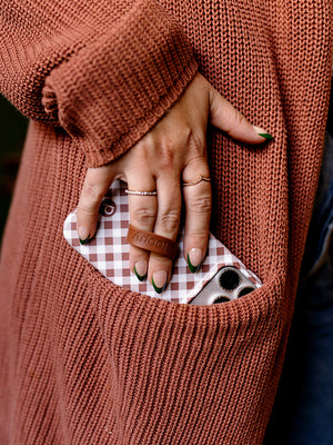 A woman holding a Brown Gingham Loopy Case. || feature-media