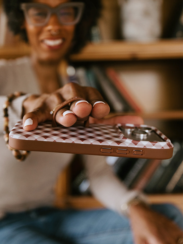 A woman holding a Brown Gingham Loopy Case. || feature-media