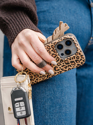 A woman holding a Cheetah Loopy Case. || feature-media