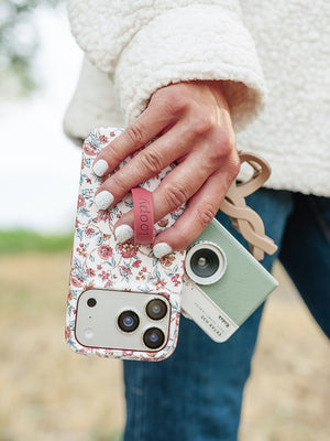 A woman holding a Chloe Floral Loopy Case. || feature-media