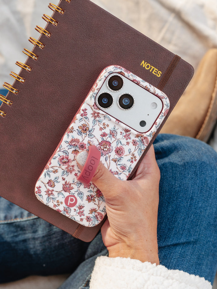 A woman holding a Chloe Floral Loopy Case. || feature-media