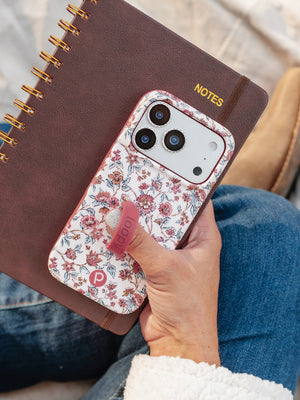 A woman holding a Chloe Floral Loopy Case. || feature-media