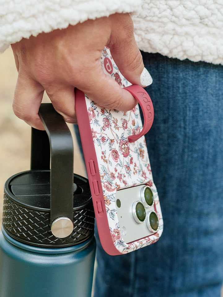 A woman holding a Chloe Floral Loopy Case. || feature-media
