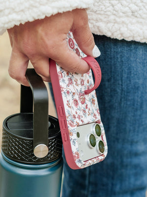 A woman holding a Chloe Floral Loopy Case. || feature-media