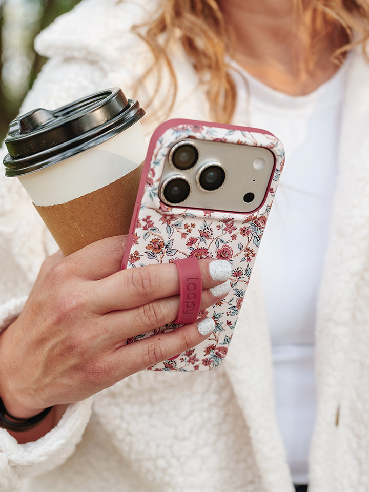 A woman holding a Chloe Floral Loopy Case. || feature-media