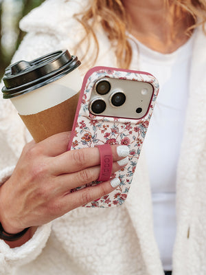 A woman holding a Chloe Floral Loopy Case. || feature-media