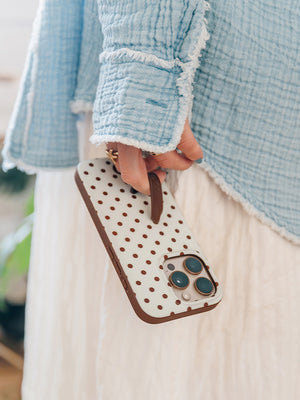A woman holding a Cocoa Dots Loopy Case. || feature-media