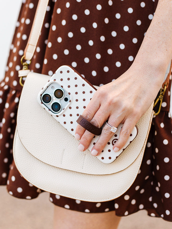 A woman holding a Cocoa Dots Loopy Case. || feature-media