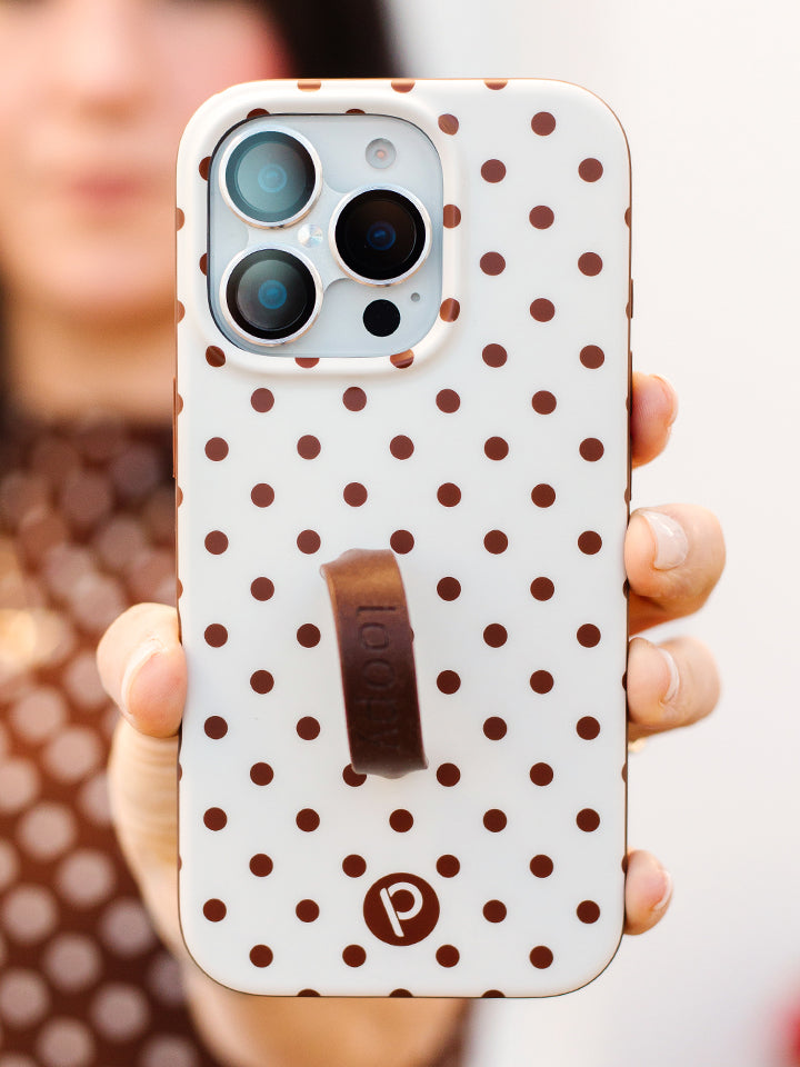 A woman holding a Cocoa Dots Loopy Case. || feature-media