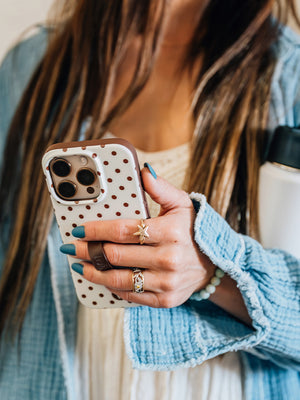 A woman holding a Cocoa Dots Loopy Case. || feature-media