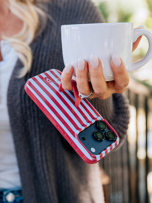 A woman holding a Cranberry Stripes Loopy Case. || feature-media