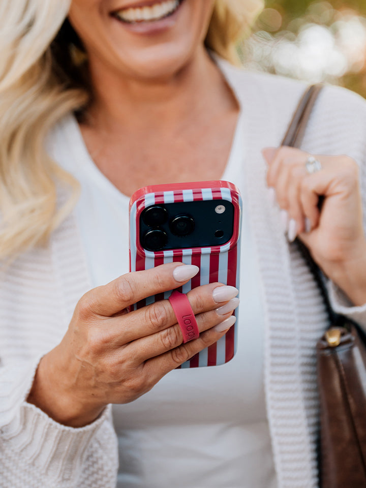 A woman holding a Cranberry Stripes Loopy Case. || feature-media