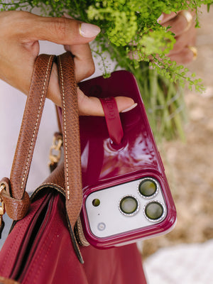 A woman holding a Dark Cherry Loopy Case. || feature-media