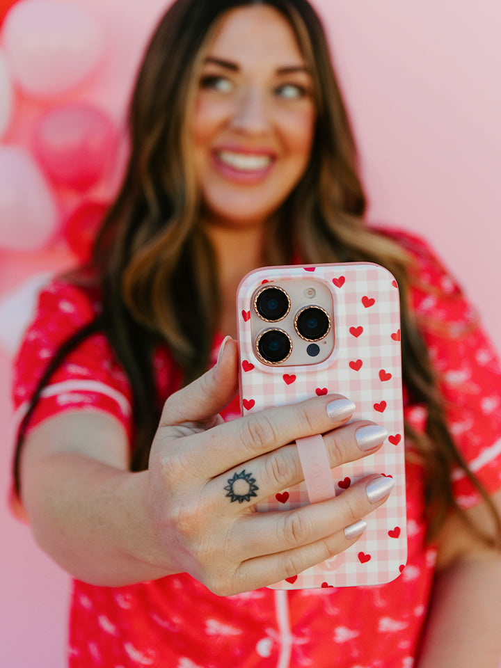 A woman holding a Galentine's Gingham Loopy Case. || feature-media