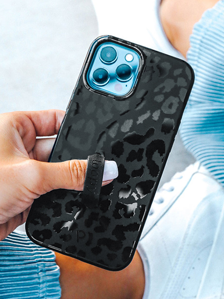 A woman holding a Midnight Leopard Loopy Case.