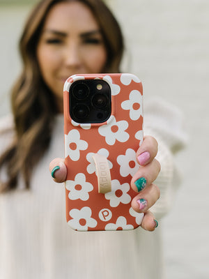 A woman holding an Auburn Daisies Loopy Case with a Sandstone Super Loop.|| feature-media
