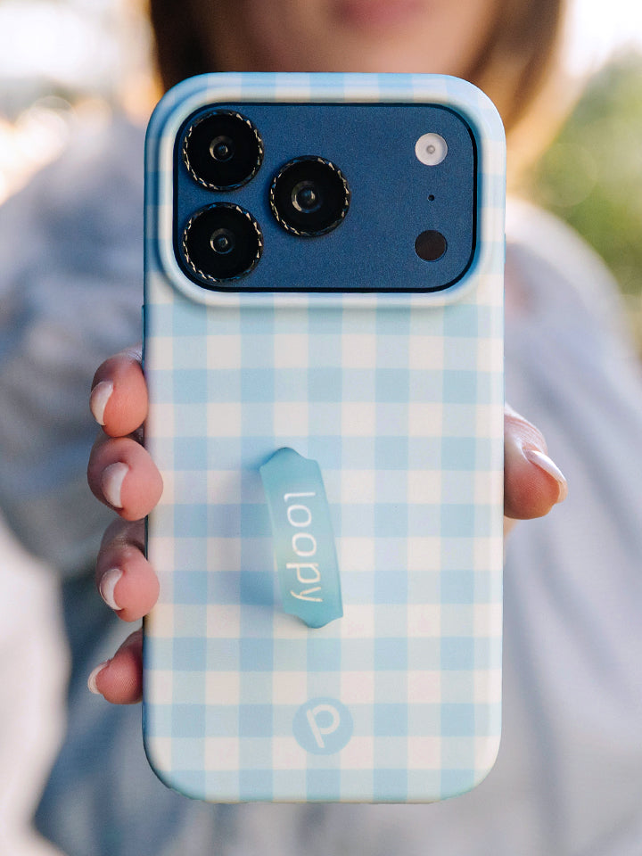 A woman holding a Blue Gingham Loopy Case. || feature-media