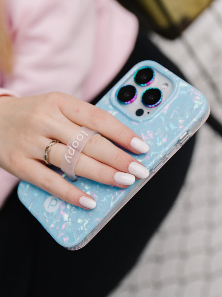 A woman holding a Blue Opal Shell Loopy Case.|| feature-media