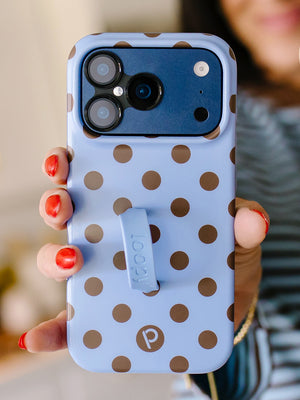 A woman holding a Blue Polka Dots Loopy Case. || feature-media