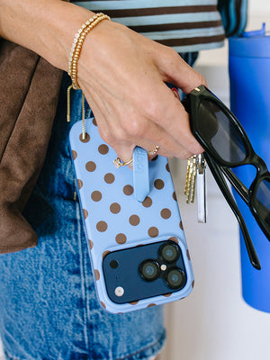 A woman holding a Blue Polka Dots Loopy Case. || feature-media